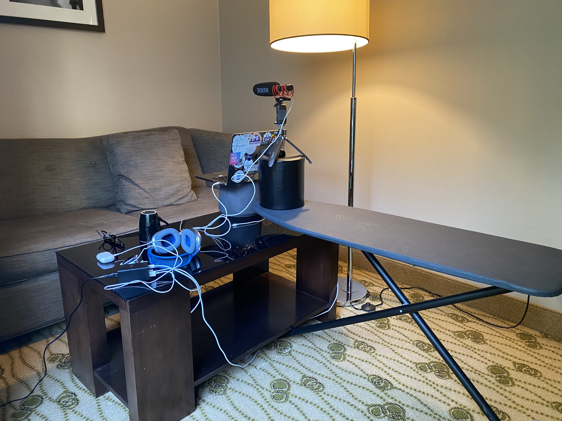 A dark brown table with a microphone and a gray sofa are visible in a room.