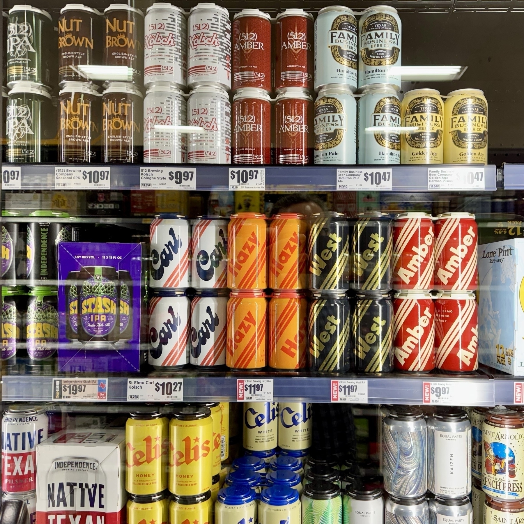 A shelf displays numerous Family Pint Amber beers and St. Emil Kolsch beers with various price tags.
