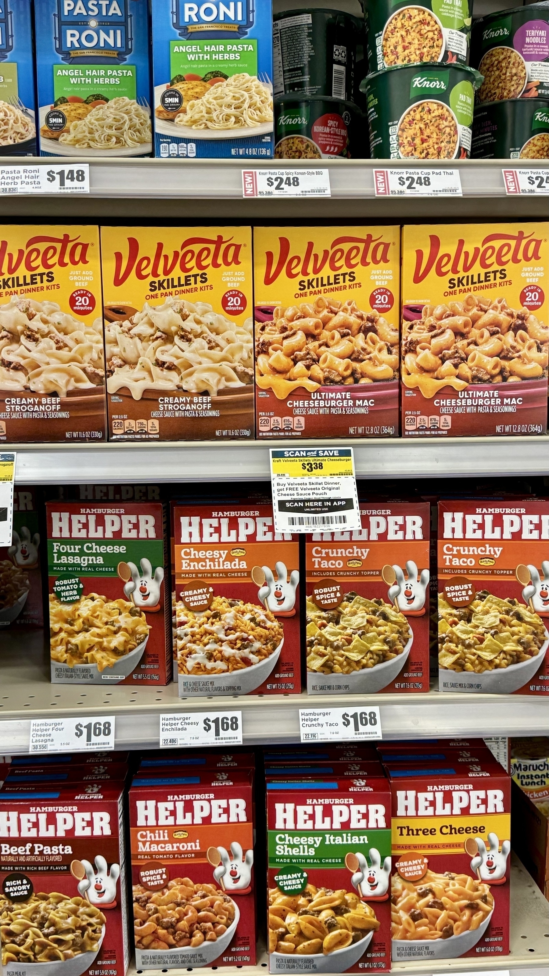 Velveeta and Knorr frozen dinner kits are displayed on a grocery store shelf.