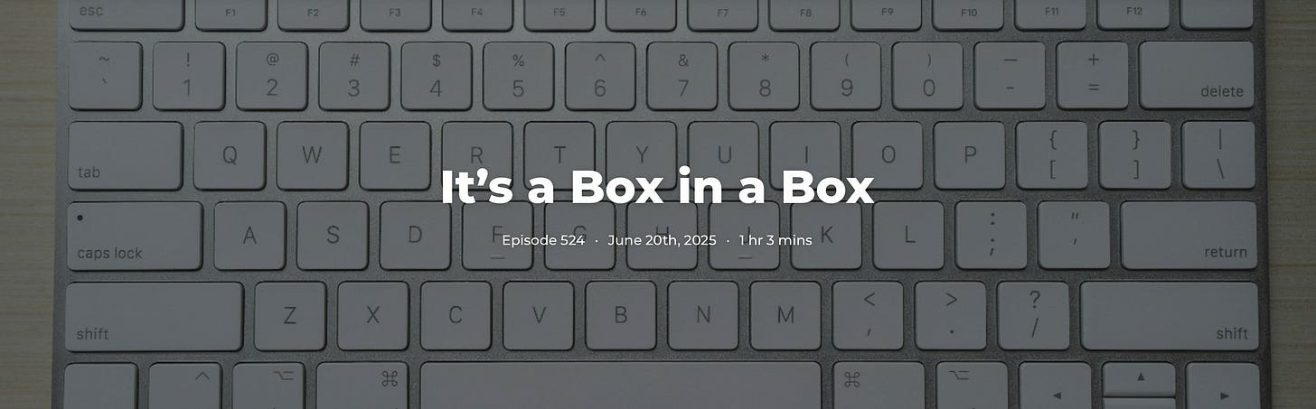 A silver Apple keyboard with the text "It's a Box in a Box Episode 524" visible.