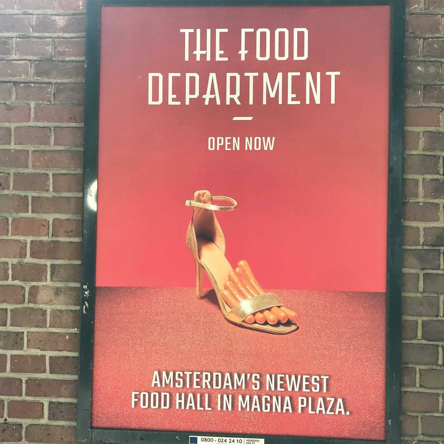 A pink sandal is displayed on a poster advertising Amsterdam’s newest food hall in Magna Plaza.