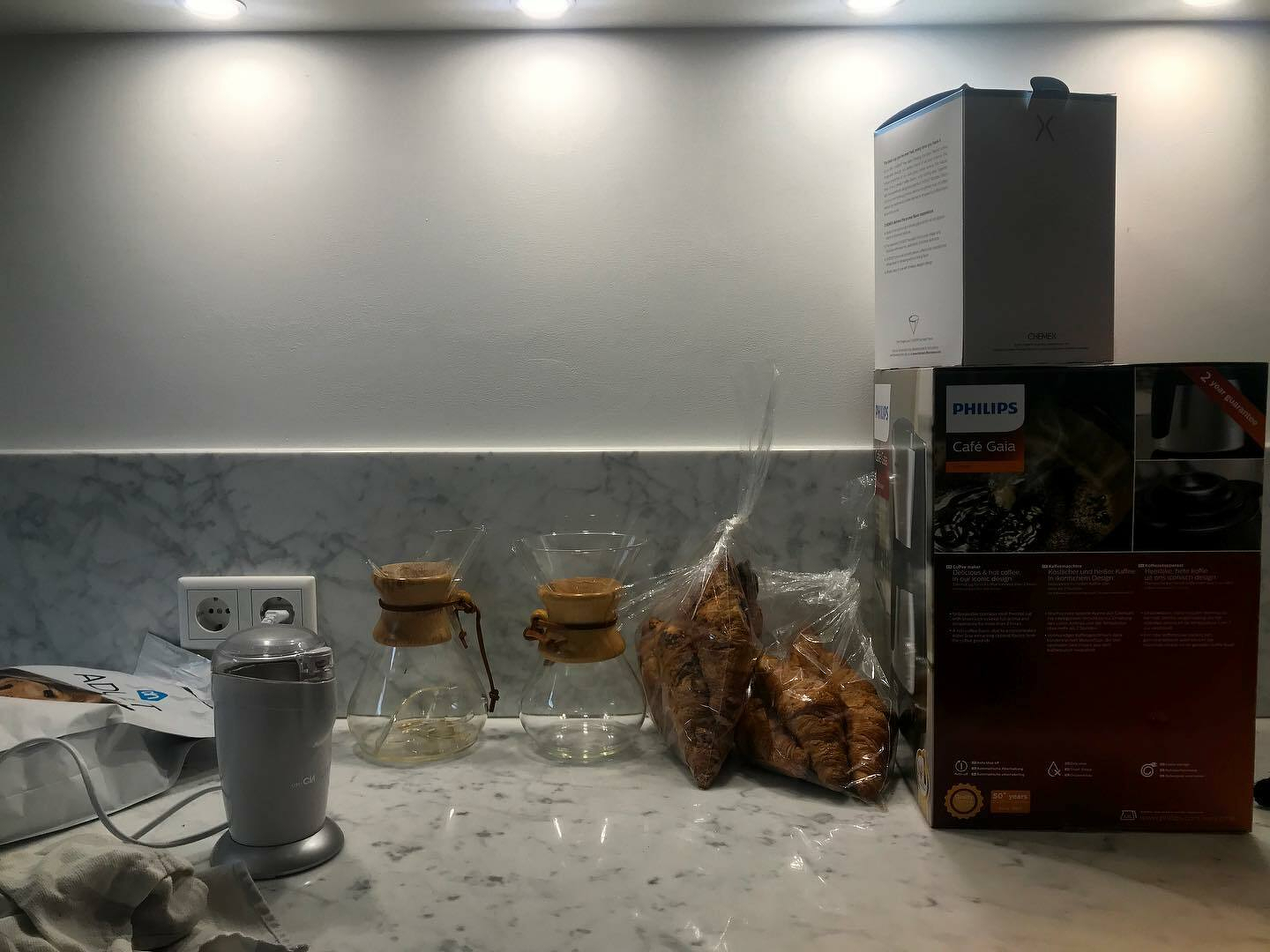 A Philips Café Gaia coffee maker sits on a countertop next to a box with product information.