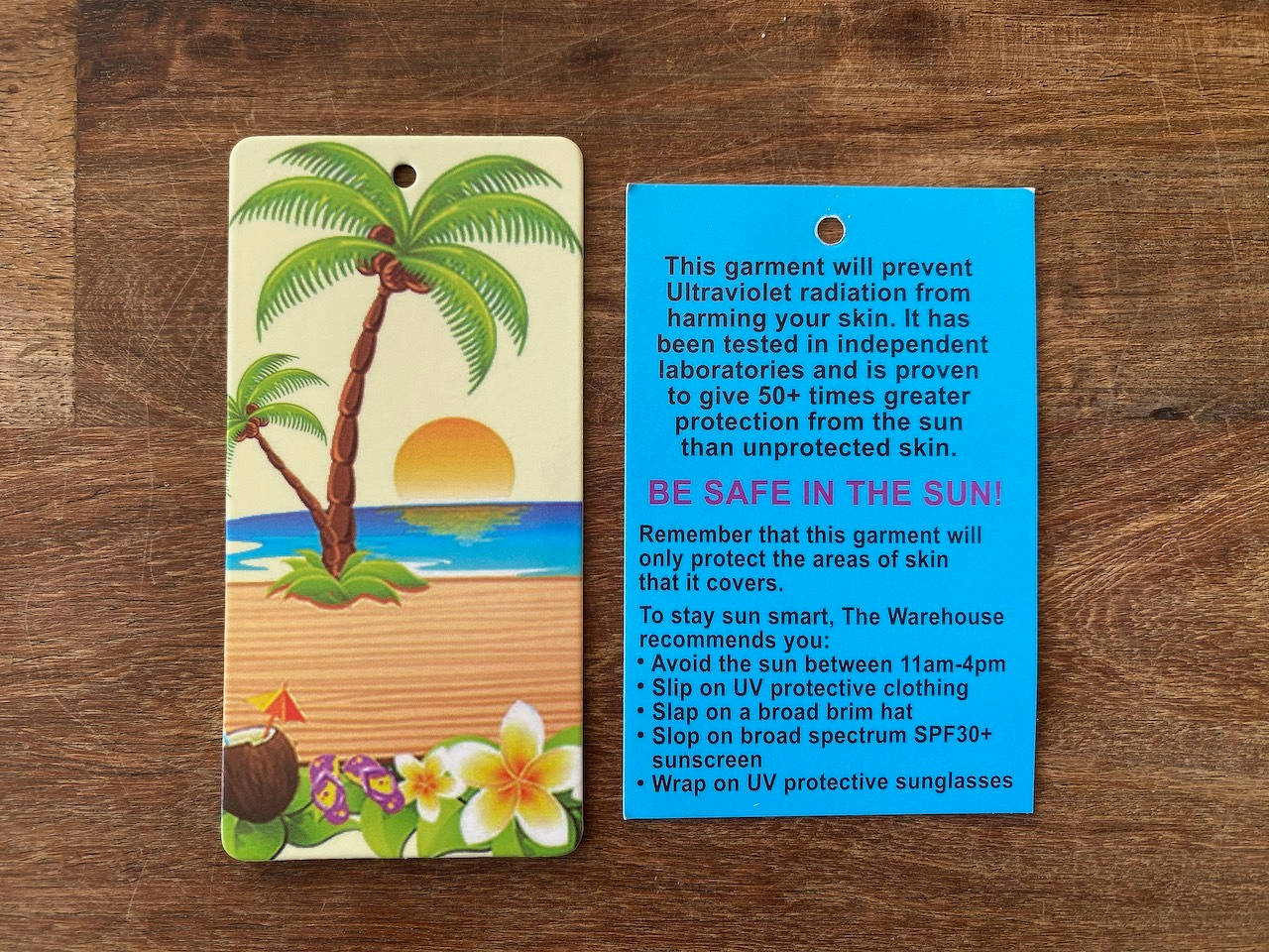 Here's a factual alt-text description of the image: A tropical-themed garment recommends sun protection with a broad-brimmed hat and sunscreen.
