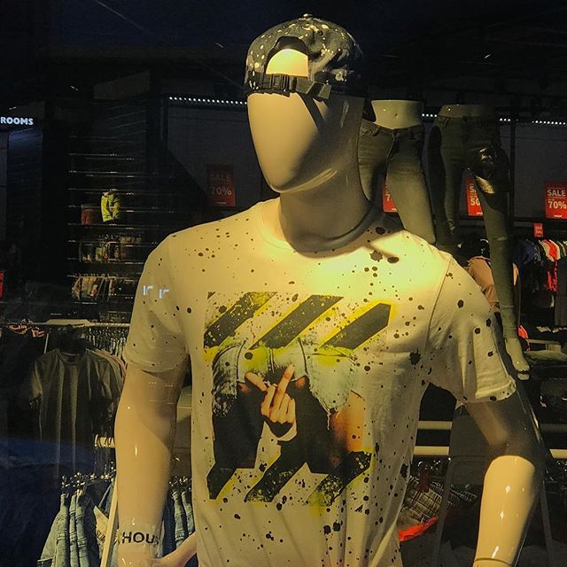 A white mannequin wears a t-shirt with a graffiti-style image and “70% OFF” sale signs are visible in the background.