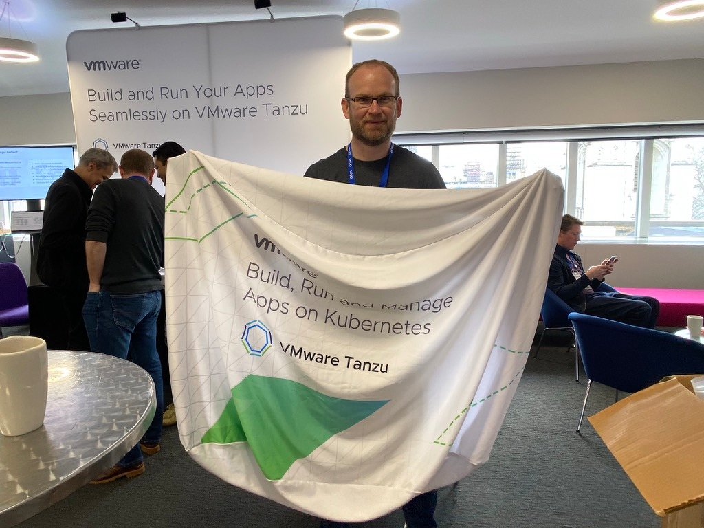 Man holding a flag promoting building and running apps on VMware Tanzu Kubernetes