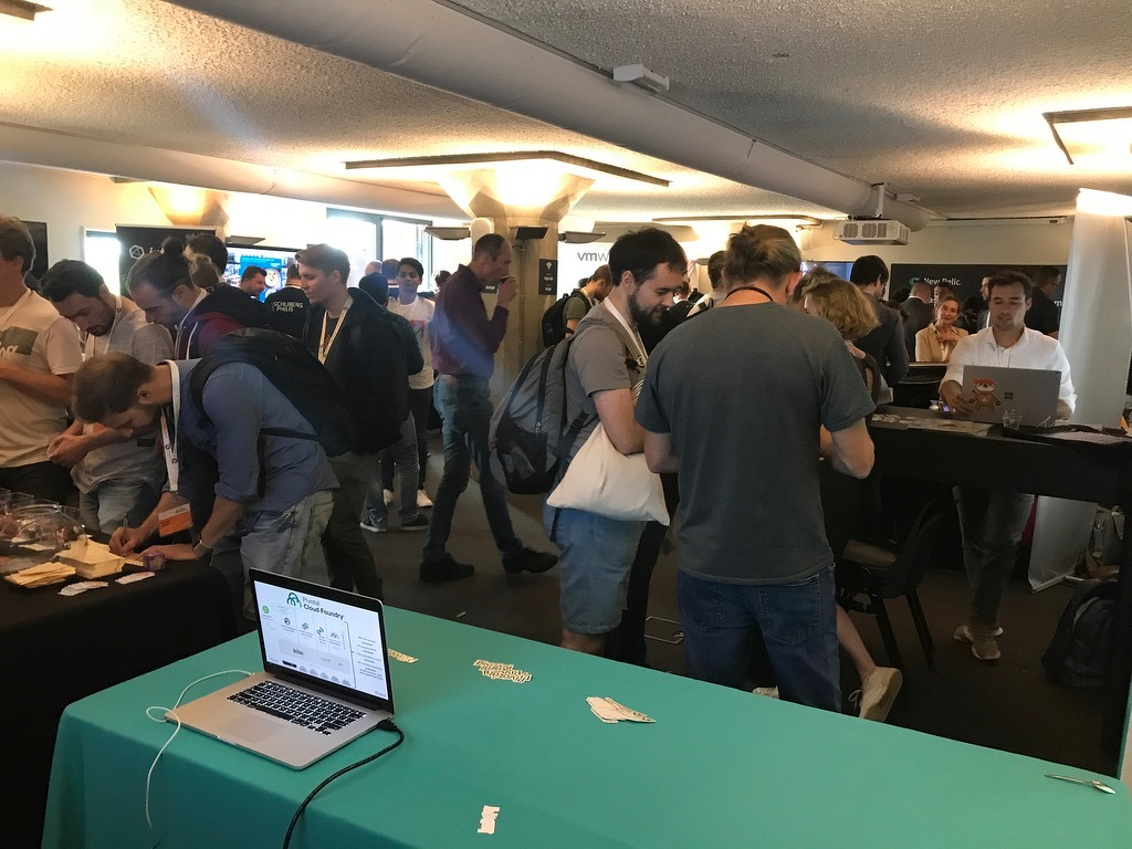 Attendees interact at a conference table with a laptop and papers