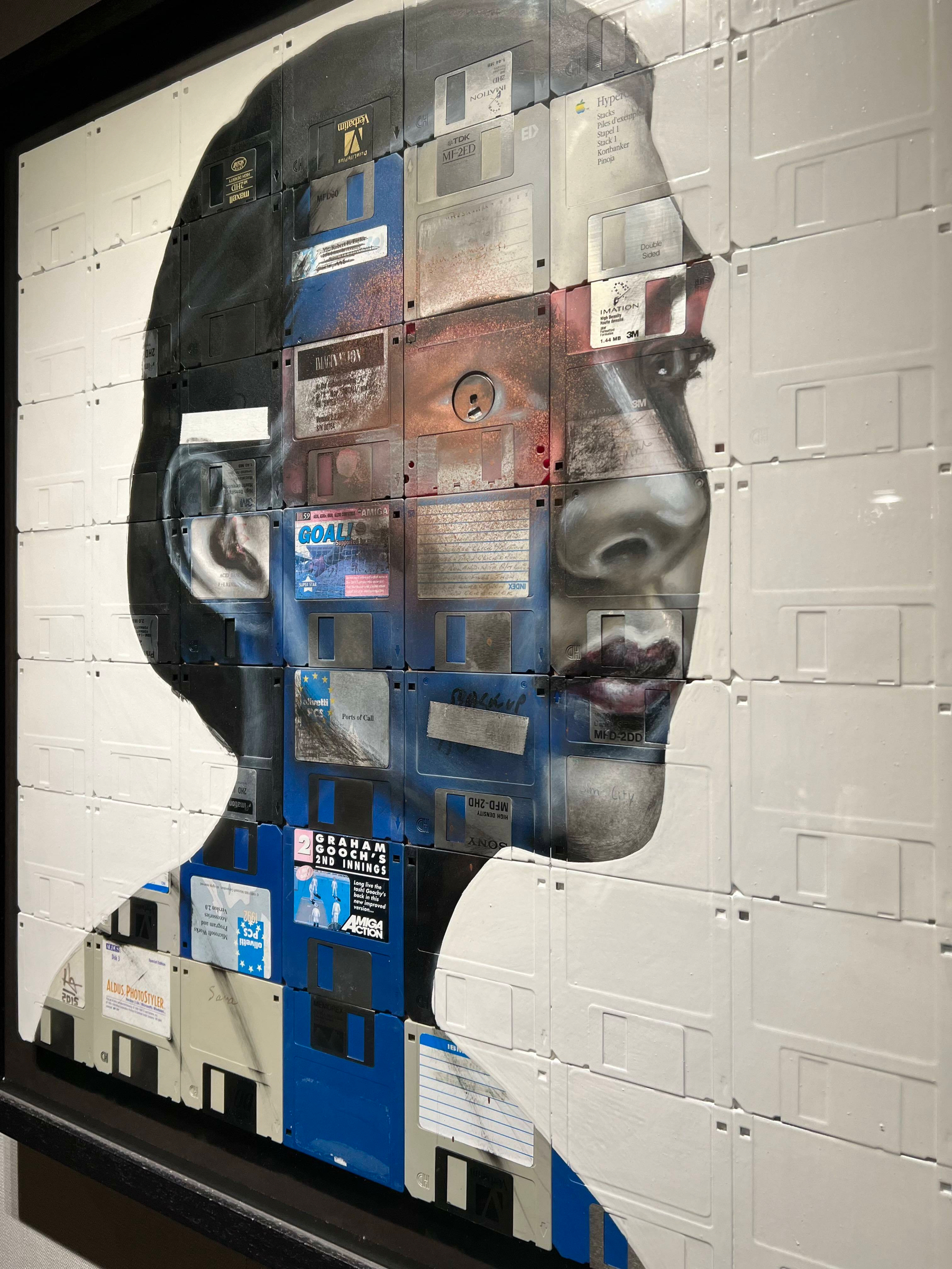 Portrait composed of stacked, colorful floppy disks against a white brick background