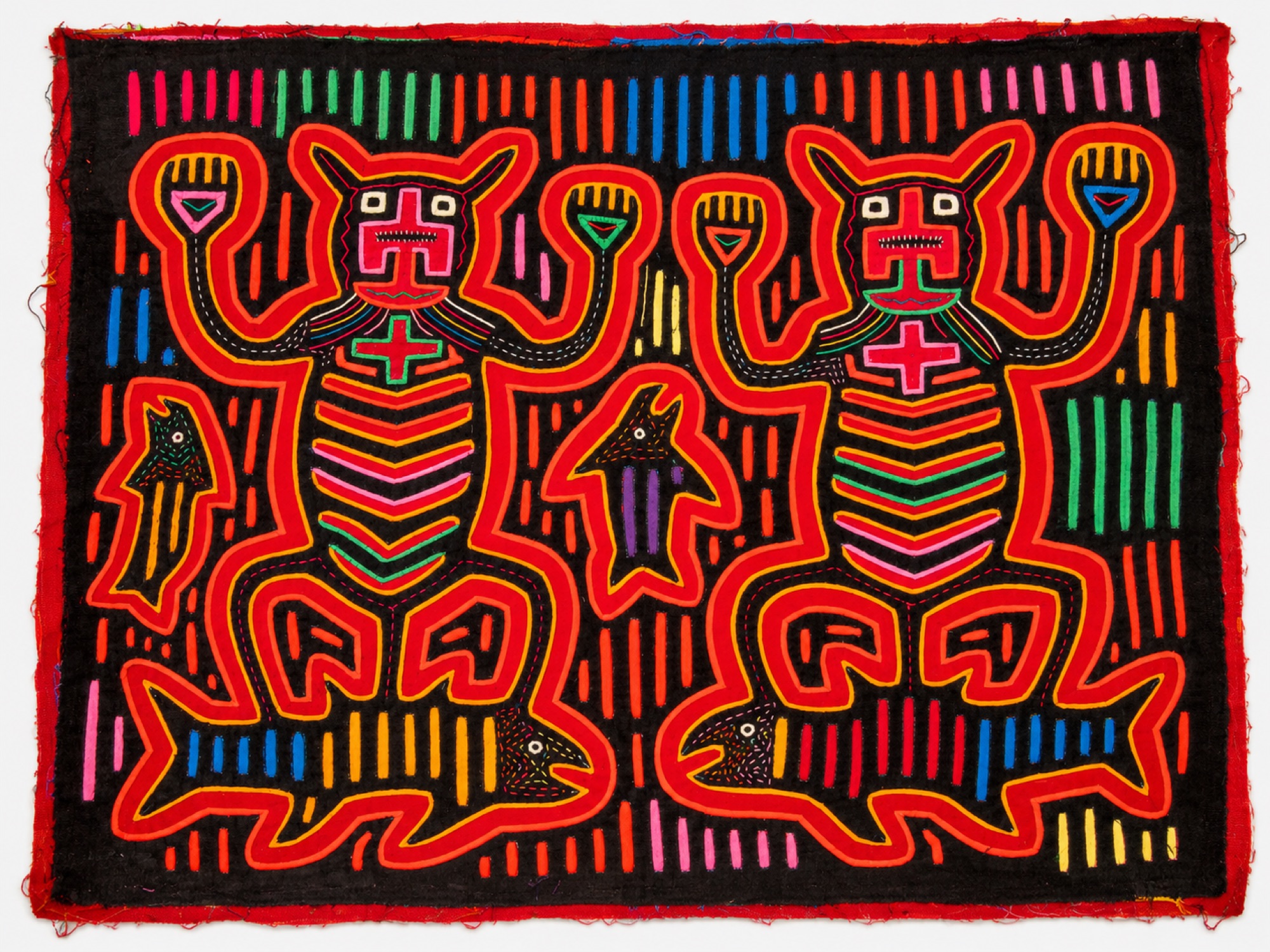 Symmetrical textile panel showing two feline figures with raised arms standing on fish against a black background with striped dashes.